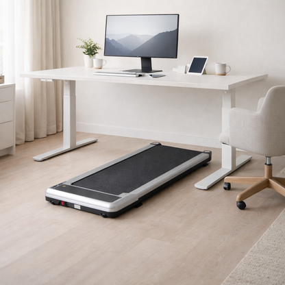 Treadmill in front of a desk with a computer setup in a home office.